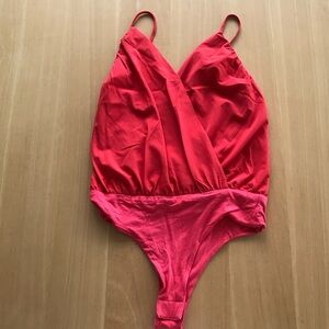 Red bodysuit with cross-back straps.